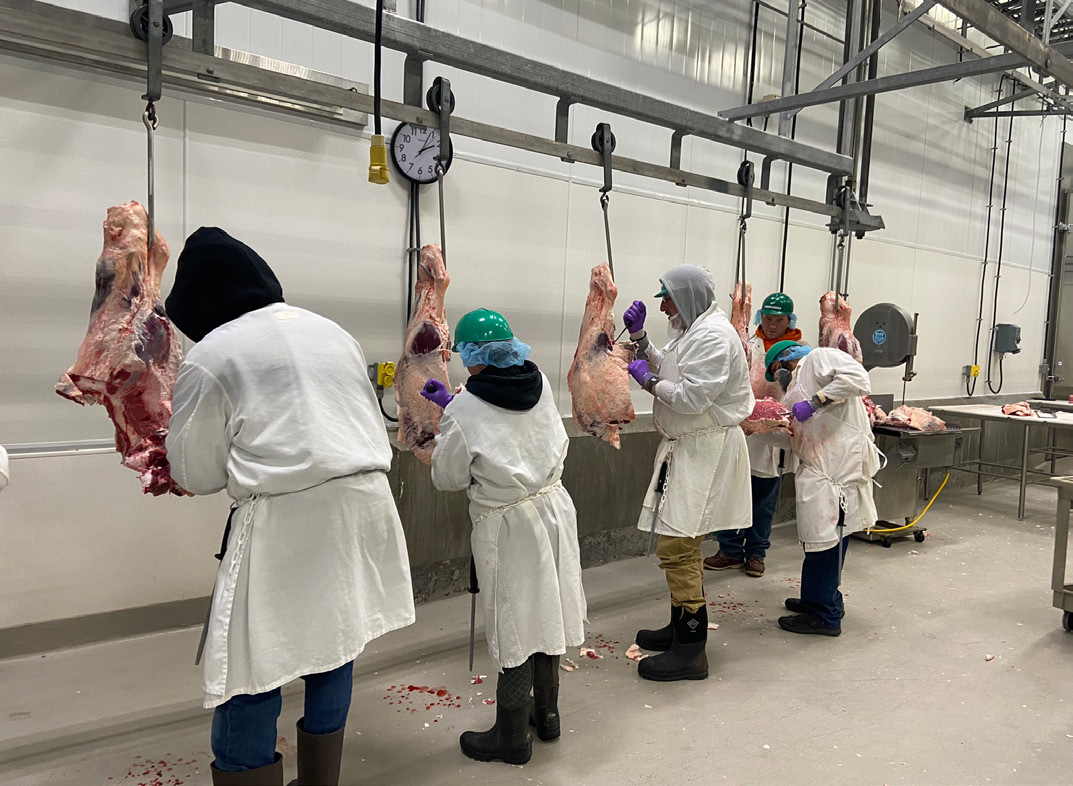 A group of people who are practicing cutting meat.